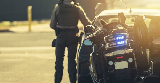 police officer approaching driver in car during traffic stop